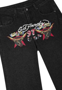Zwarte denim jeans met kleurrijke Ed Hardy-logo's, twee stierenkoppen, "97" in rood en de tekst "USA" aan de voorkant op het dijbeen.