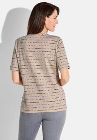 Beige Kurzarmhemd mit horizontalen Streifen in Dunkelblau und Hellblau. Weicher Stoff mit lockerer Passform und rundem Halsausschnitt.