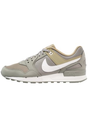 Chaussure de course Nike basse en beige et gris avec logo swoosh blanc, bout en mesh, fermeture à lacets et semelle en caoutchouc texturée.
