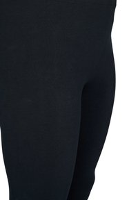 Mustad retuusid sileda, veniva tekstuuriga, millel on jalgu järgiv istuv disain ja lihtne, õmblusteta vöökoht.