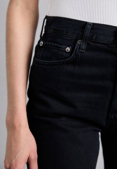 Black denim jeans with a high waist, featuring silver hardware, a front pocket, and a sleek, slightly textured finish.