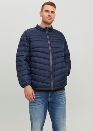 Chaqueta de plumas navy con diseño acolchado, cierre frontal completo y cuello de pie. Presenta puños elásticos y costuras horizontales para aportar textura.