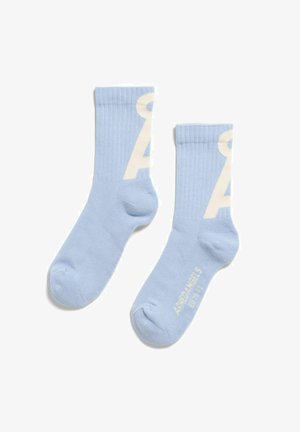 Paar hellblaue Knöchelsocken mit weißem teilweisem Buchstabendesign und kleinem Text "AME ANGELS" nahe den Zehen auf weißem Hintergrund.