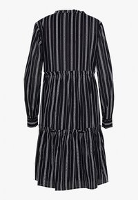 Vestido negro con rayas verticales blancas, de manga larga, con cintura fruncida y dobladillo en capas. Hecho de una tela ligera, presenta un escote con volantes.