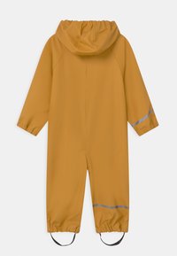 Gul vattentät regnoverall med huva, elastiska cuffar och reflexband på ärmar och ben. Slät textur, praktisk design.