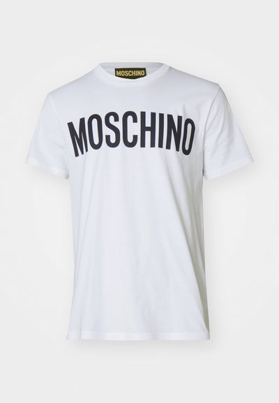 Camiseta de algodón blanca con "MOSCHINO" en letras negras en negrita en el pecho. Mangas cortas y cuello redondo.