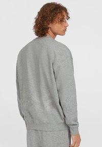 Grijze sweatshirt met lange mouwen en geribde boorden. Zachte textuur en een ontspannen pasvorm, met een ronde hals en een effen ontwerp.