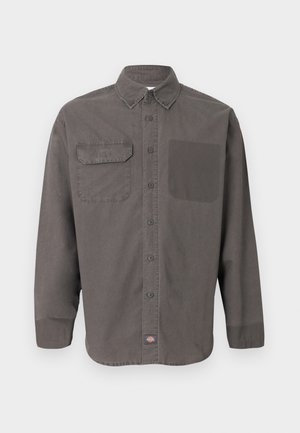 Dunkelgraues Hemd mit langen Ärmeln, Knopfleiste, Kragen, zwei Brusttaschen (eine mit Klappe) und kleinem Logoetikett am Saum.