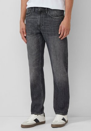 Dark denim jeans with a straight cut, featuring a slightly faded finish, five pockets, and a zip fly, paired with white sneakers.