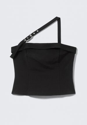 Sort asymmetrisk cropped top med en justerbar spænde strop og en tynd skulderstrop, minimalistisk design på ensfarvet baggrund.