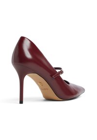 Décolleté in vernice bordeaux con punta affusolata, cinturino alla caviglia e sottile tacco a stiletto. Presenta un taglio arrotondato vicino alla punta.