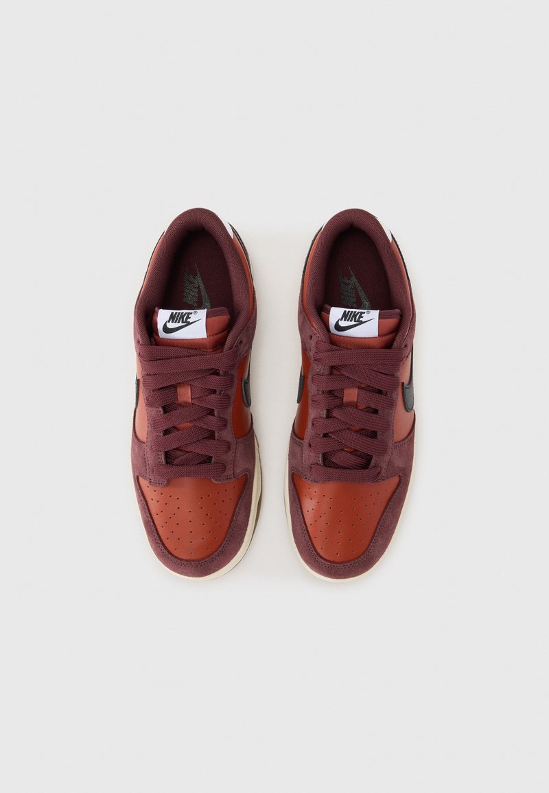 Baskets Nike avec un dessus en daim bordeaux et cuir marron, accents cousus, embout perforé et semelle en caoutchouc blanche.
