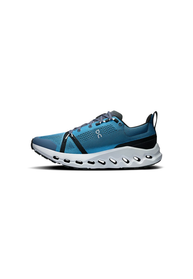 Baskets de sport bleues avec une tige en mesh, une semelle extérieure en caoutchouc, des accents noirs et une semelle distinctive rembourrée avec des découpes.