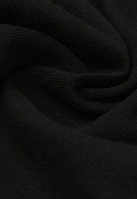 Schwarzer Strickstoff mit einer weichen Textur, der ein glattes, gleichmäßiges Gewebe und einen subtilen Glanz aufweist, in sanften Falten arrangiert.