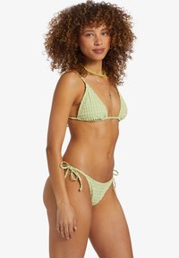 Green checked bikini featuring a triangle top with thin straps and a bottom with tie sides. Textured fabric adds dimension.