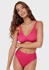 Conjunto de bikini de color rosa acanalado que presenta un top de escote en V con tirantes anchos y braguitas de cintura alta, que muestran una textura suave y un diseño ajustado.