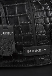 Borsa a tracolla in pelle nera con motivo texturizzato a coccodrillo, dettagli in hardware argentato e logo impresso.