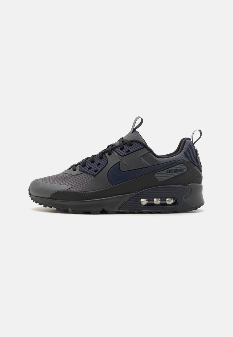 Sapatilha Nike Air Max em cinza escuro e azul marinho, apresentando materiais em malha e sintéticos, uma sola acolchoada e uma unidade de ar visível no calcanhar.