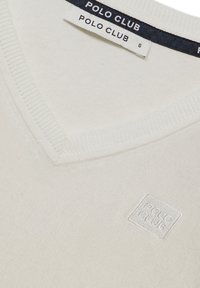 Pull col V couleur crème avec « Polo Club » brodé sur la poitrine et étiquettes indiquant la marque et la taille small.