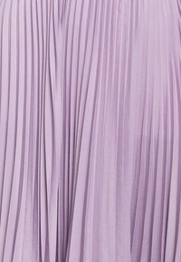 Plisovaná levandulová látka s vertikálními pruhy, měkkou strukturou a hladkým povrchem. Má splývavý design a jemný lesk.