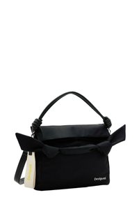 Sac à main noir avec une poignée à détail en noeud, en tissu lisse, accentué par un grand nœud et une étiquette logo amovible. Il dispose d'une fermeture éclair pour plus de sécurité.