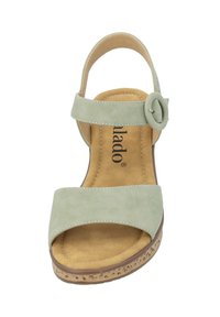 Sandal in suede verde con una larga cinghia, dettaglio con fibbia circolare e suola in sughero beige. Presenta una soletta morbida per il comfort.