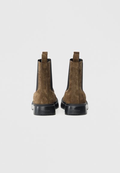 Καφέ σουέτ μποτάκια Chelsea με μαύρα ελαστικά πάνελ και χοντρή λαστιχένια σόλα. Διαθέτουν γλωττίδα στο πίσω μέρος για εύκολο φόρεμα.