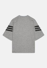 Camiseta gris de manga corta con mangas raglán, que cuenta con tres rayas horizontales negras en cada manga, fabricada en una suave mezcla de algodón.