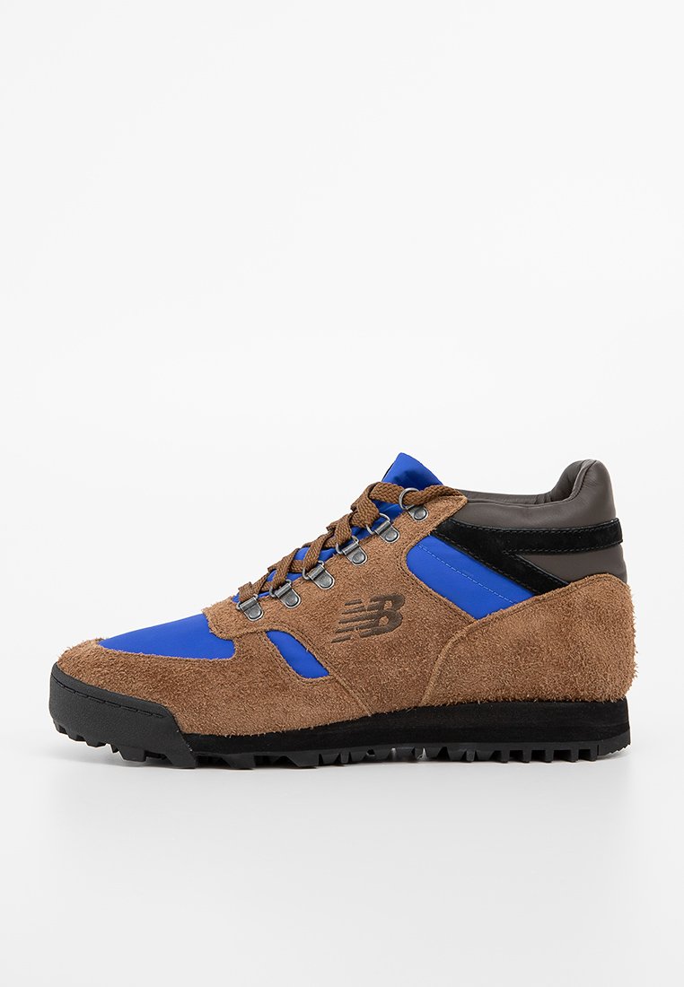 Bruin suède en blauwe nylon wandelschoen met zwarte accenten, vetersluiting en een gestructureerde rubberen zool. Bevat een logo op de zijkant.