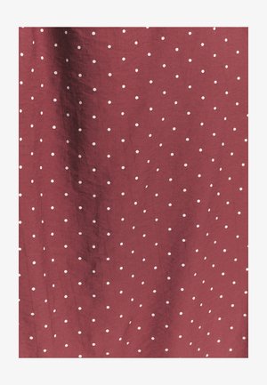 Viininpunainen kangas, jossa pehmeä rakenne ja tasaisesti jakautuneet pienet valkoiset pallokuvioinnit.