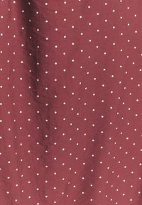 Tessuto bordeaux con pois bianchi, caratterizzato da una consistenza morbida e una finitura liscia. Motivo a pois ripetuto, uniformemente distribuito sul materiale.