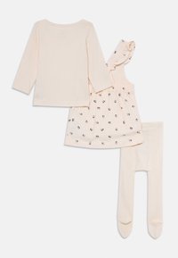 Set di abbigliamento per neonati di colore crema composto da top a maniche lunghe, vestito senza maniche con stampa floreale e spalline con volant, e collant coordinati.
