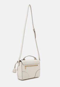 Olkalaukku valkoisesta teksturoidusta nahasta, jossa kullanväriset metalliosat, yläkädensanka, säädettävä olkahihna, etutasku vetoketjulla ja kaarevat tikkausyksityiskohdat.