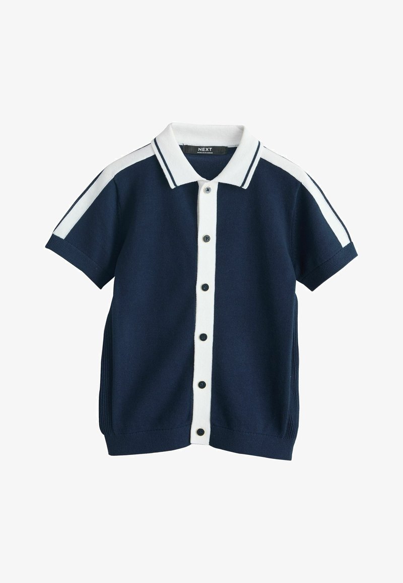 Tricou bleumarin cu mâneci scurte din tricot, cu pată de nasturi albă, guler alb și dungi albe de-a lungul umerilor și mânecilor.