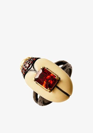 Anillo con pieza central ovalada de color crema, gran piedra preciosa roja rectangular en engaste de oro y banda oscura con pequeñas piedras rojas.