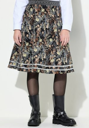 Kjole med blomsterprint og knælængde med blonderkant, kombineret med sorte gennemsigtige strømpebukser og sorte læderstøvler med spænde.