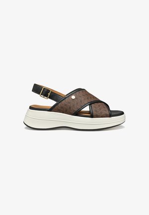 Sandalo slingback marrone e nero con cinturini incrociati decorati, fibbia regolabile, suola bianca imbottita e piccolo logo rotondo in metallo.