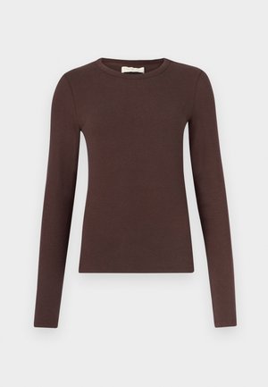 Brun bluse med lange ærmer lavet af blødt, elastisk stof. Har rund halsudskæring og en figursyet silhuet med en glat tekstur.