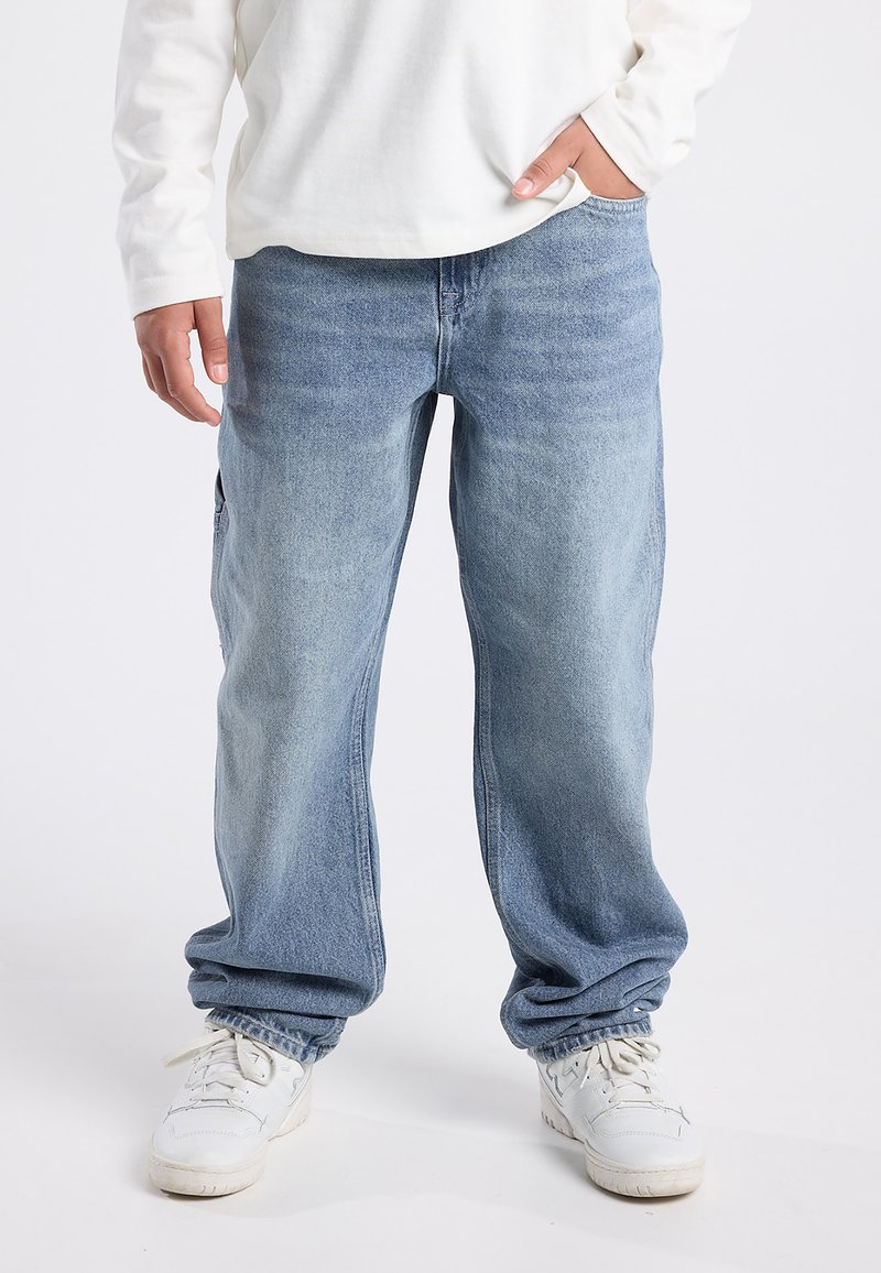 Light blue denim jeans with a relaxed fit, featuring subtle fading and a straight leg design, paired with white sneakers.