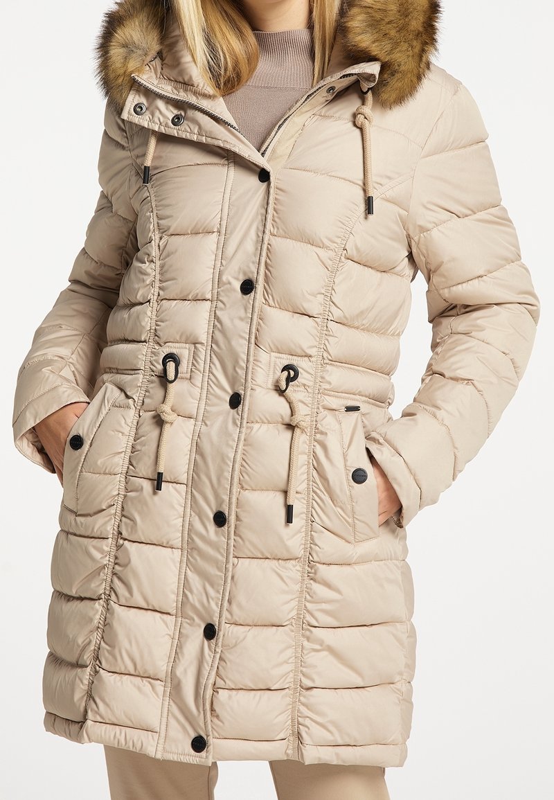 Beige pufferjack met een afneembare bontgevoerde capuchon, rits- en knoopsluiting, taille met trekkoord en twee voorzakken. Gelaagd, gewatteerd ontwerp.