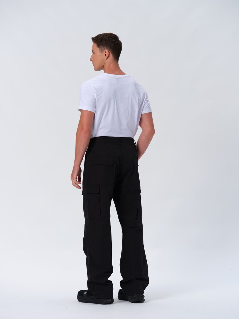 Sorte cargo-bukser med flere sidelommer, parret med en ensfarvet hvid t-shirt med korte ærmer, set fra ryggen. Glat stofstruktur.