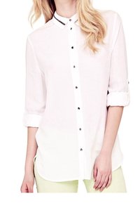 Chemise blanche à boutons avec un design superposé, caractérisée par un col contrastant avec une bordure décorative et des boutons noirs sur le devant.