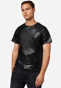Schwarzes T-Shirt mit kurzen Ärmeln aus glattem Leder, runder Ausschnitt und taillierter Silhouette. Strukturiert Oberfläche mit minimalen Nähten.