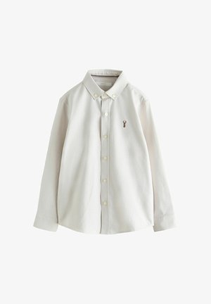 Langärmliges, weißes Hemd mit Knopfleiste, Kragen und kleinem braunem Hirsch-Emblem auf der linken Brustseite.