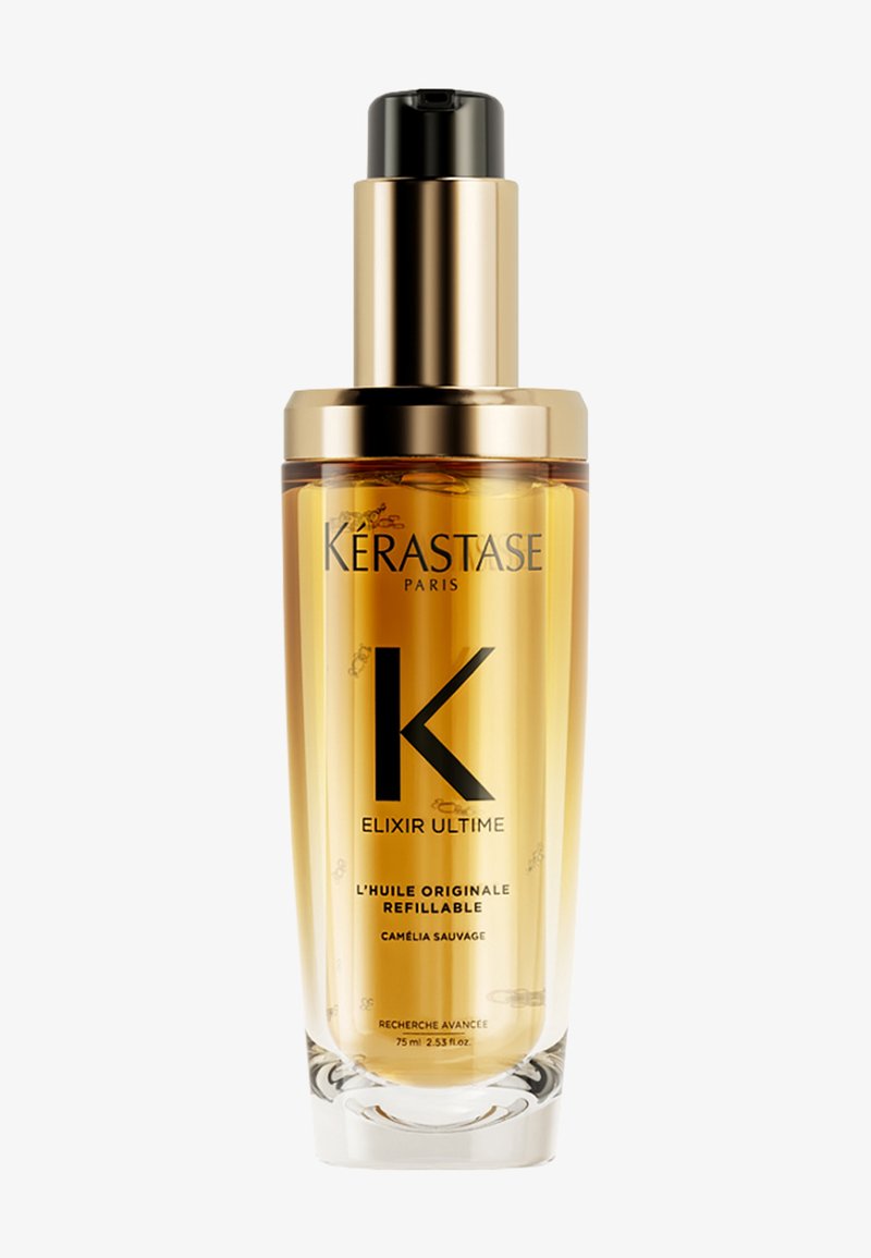 Flacon transparent avec huile pour cheveux dorée étiquetée Kérastase Elixir Ultime rechargeable Camélia Sauvage avec un distributeur pompe or et noir.