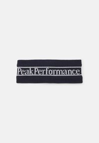 Námornícky pletený čelenka s bielym pásom s logom "Peak Performance", obdĺžnikový tvar, elastická textúra a hladký povrch.
