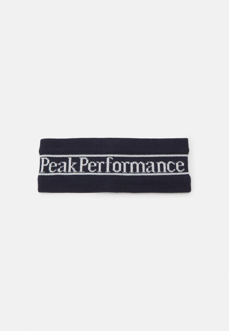 Námornícky pletený čelenka s bielym pásom s logom "Peak Performance", obdĺžnikový tvar, elastická textúra a hladký povrch.