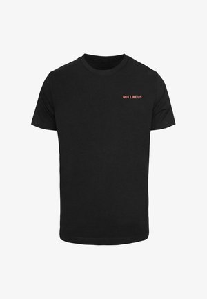 Camiseta de algodón negra con mangas cortas, que presenta la frase "NO COMO NOSOTROS" en rojo en la parte superior izquierda. Diseño clásico de cuello redondo.