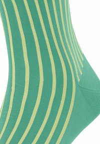 Calze verde chiaro con strisce verticali gialle. Tessuto lavorato a maglia con una finitura liscia. Design del tallone curvo, ideale per comfort e vestibilità.