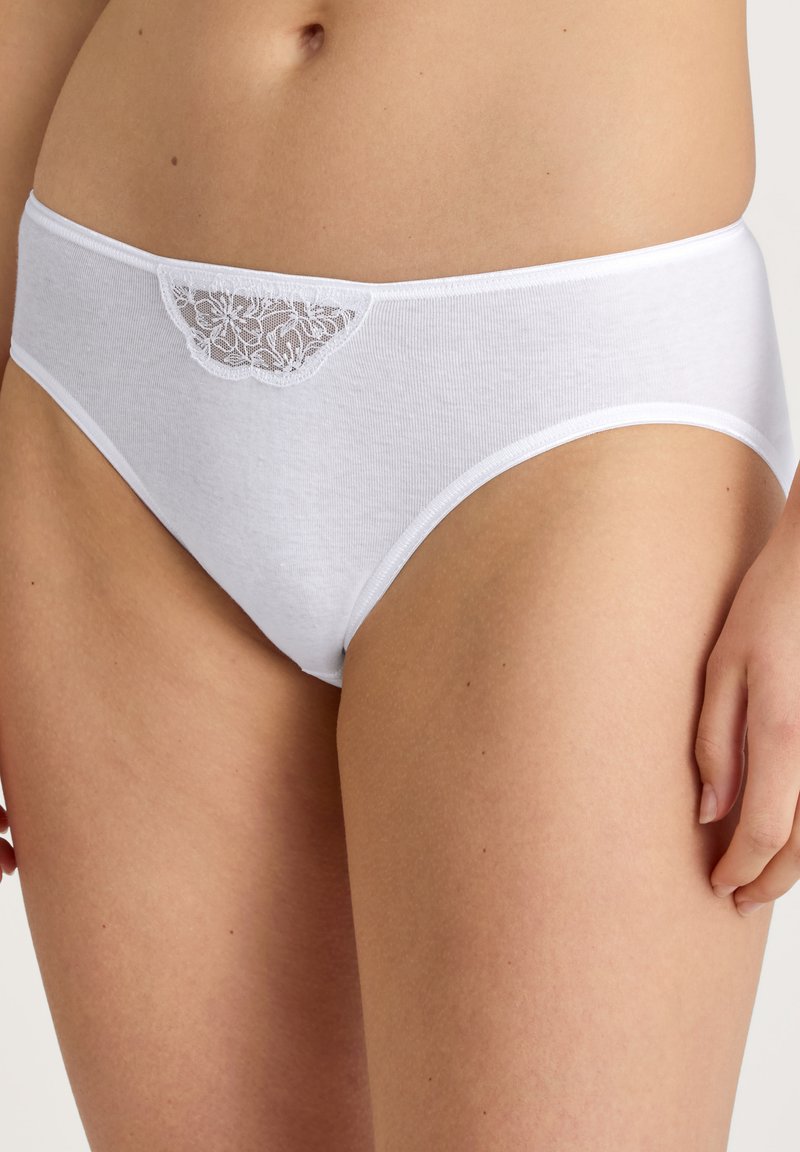 Culotte da donna in cotone bianco con un accento di pizzo floreale in vita. Texture liscia con un taglio classico e copertura moderata.